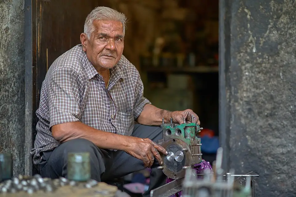 A mechanic working on a motor component in his Mumbai workshop, India, September 2018.